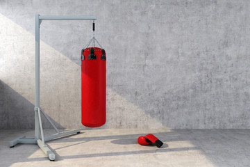 red punching bag with a concrete wall