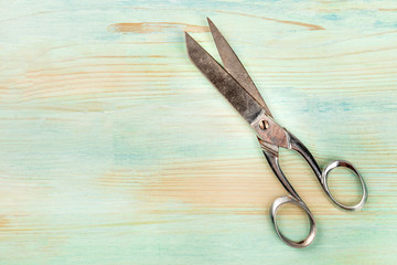 Vintage scissors, shot from the top on a teal blue background with a place for text