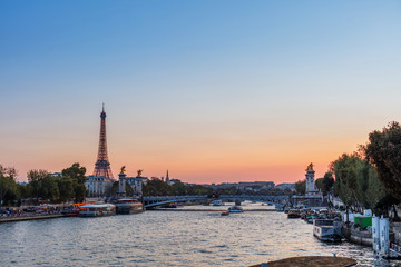 Sunset view of Eiffel tower, Alexander III and Seine river in Paris, France. Architecture and landmarks of Paris.