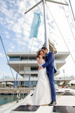 A couple of newly married lovers sail on a sailboat in a romantic attitude