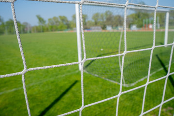  Empty football playground. Soccer football net and blurry stadium. Close up detail of a soccer net Football soccer field. Hang bended white 