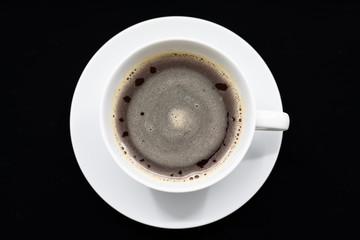 Black cup of coffee on a black background