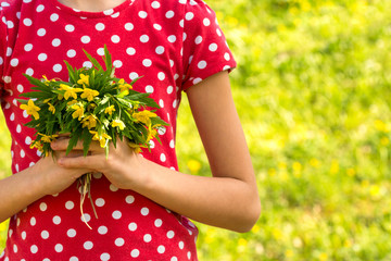 Girl hands holds small bouquet of wildflowers
