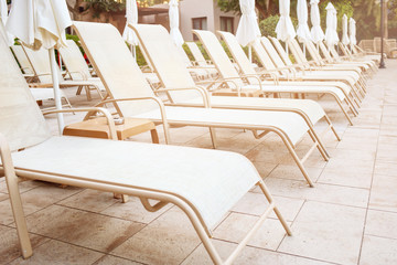 Many deck chairs standing on the hotel territory.