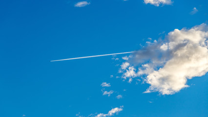 Aircraft at the blue sky, condensation trail