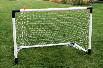 The small goal for the soccer on the green field in the garden