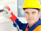 Smiling electrician repairing a <b>power plan</b> - 160_F_23083706_zkwyZKJpyh8L7VDomgyG1nVwjCJLrY4g