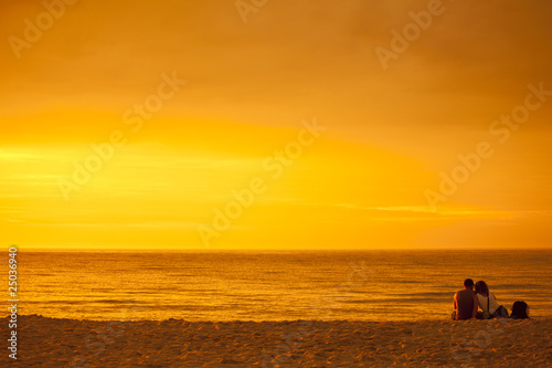  Zakochana para podziwiająca zachód słońca nad morzem