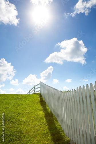 Fototapeta white fence, grass and sky