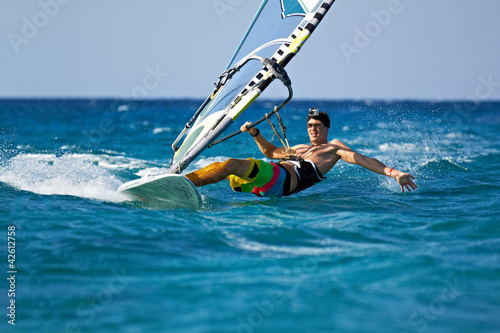 mlody-czlowiek-surfing-wiatr-w-plamy-wody