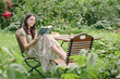 Junge Frau im Garten ließt ein Buch