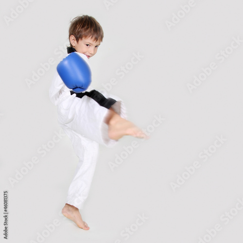 young boy kickboxing fighter in white kimono isolated on white © Alena Yakusheva