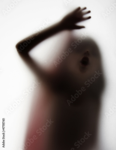 Fototapeta a dark girl silhouette behind a transparent paper