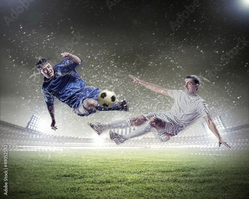 Fototapeta two football players striking the ball