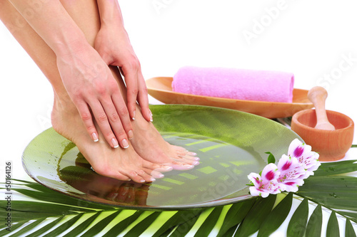  Female feet in spa bowl with water, isolated on white