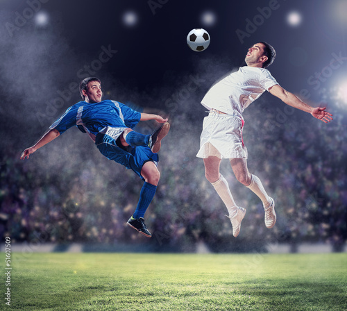 Fototapeta two football players striking the ball