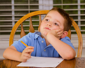 Thoughtful child doing his homework at <b>kitchen table</b> - 240_F_52034766_mxG5mvfBGS5jVwSpO7wSLFQPEh7O9nnm