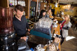 Bartender Working At Counter While Female Colleague Serving Coff