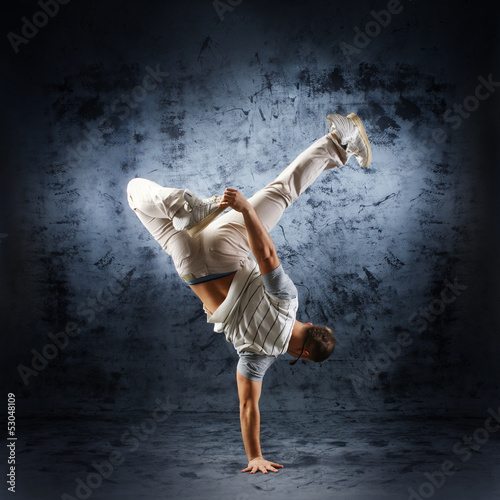 Fototapeta A young and sporty modern dancer on a grunge background