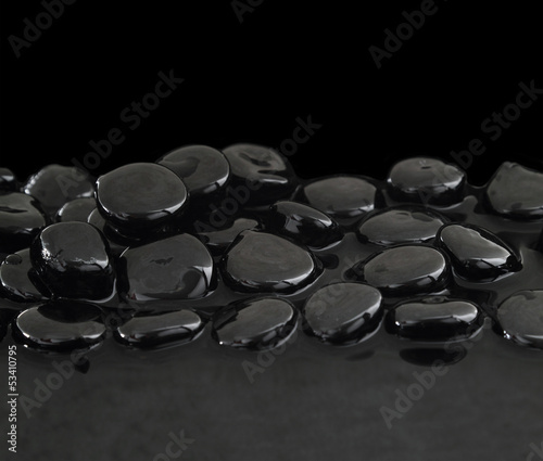 Black stones on calm water background