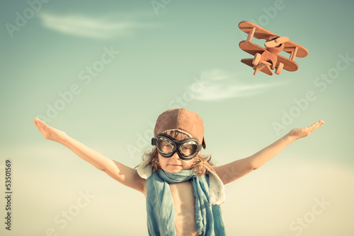 Fototapeta Happy kid playing with toy airplane