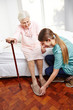 Altenpfleger hilft Seniorin beim Aufstehen