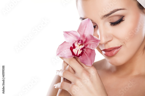 Fototapeta young woman with a towel on her head posing with orchid