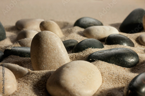  Closeup of stones sticking out of the sand in the sunlight