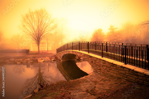  morning light and fog over pond with footbridge