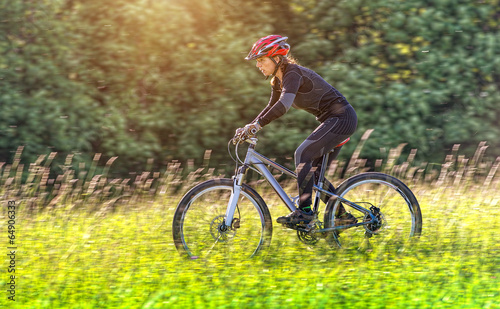 Fototapeta Sport bike woman in a beautiful meadow