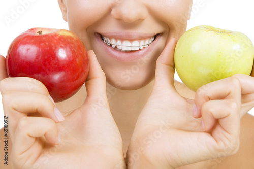Fototapeta smiling girl with retainer for teeth and apple, Isolated on whit