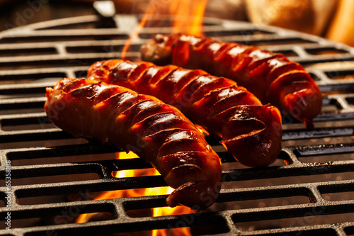  Grilling sausages on barbecue grill