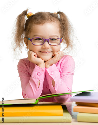  child girl in glasses reading book and smiling