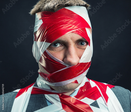 Man with stripped duct tape over body