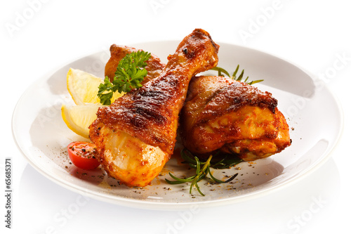  Grilled chicken legs and vegetables on white background