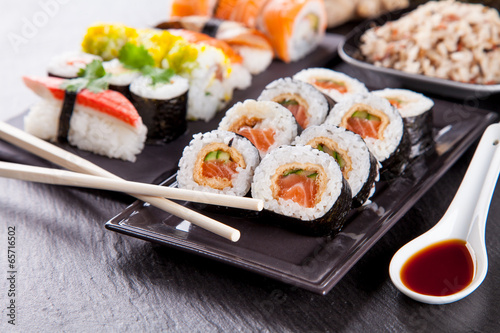 Delicious sushi pieces served on black stone