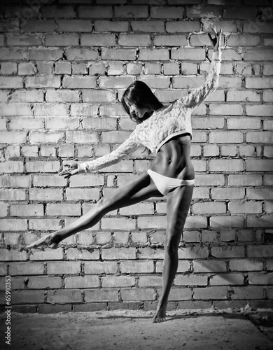 Fototapeta Dancing young woman on wall (monochrome version)