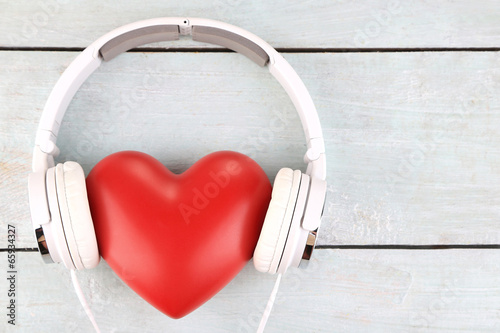  Headphones and heart on wooden background