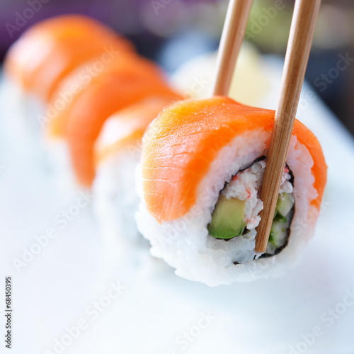 picking up a piece of sushi with chopsticks