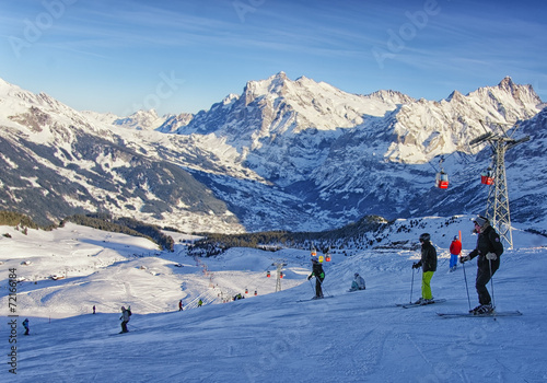  Men and women on ski and snowboards near cable railway on winte