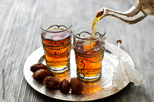 Traditional arabic tea with dates and sugar on a plate Poster
