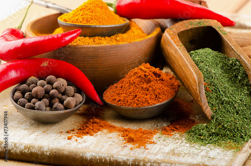spices on spoons on  wooden background