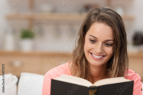 glückliche frau liest ein buch zu hause