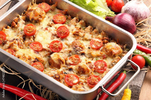 Casserole with rice meatballs and vegetables on wooden backgroun