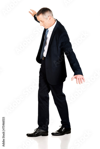 Full length businessman walking carefully