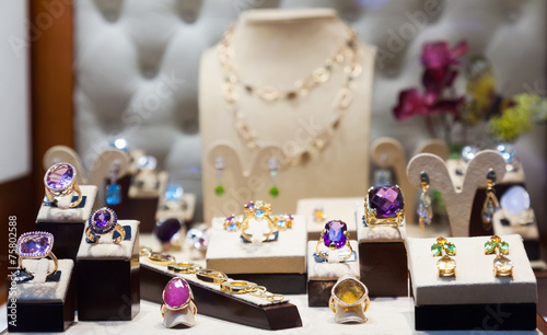 Golden jewelry with gems at showcase