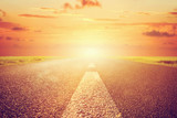 Long empty asphalt road towards sunset sun. poster