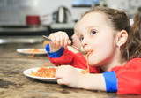 Little girl eat pasta in the <b>kitchen table</b> - 160_F_77641927_vcrJhVH49mq6c7hxD6i2kfY3kNPXn0EZ