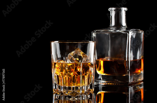 Glass of whiskey with ice and a square decanter