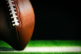 American football on green grass, on black background poster